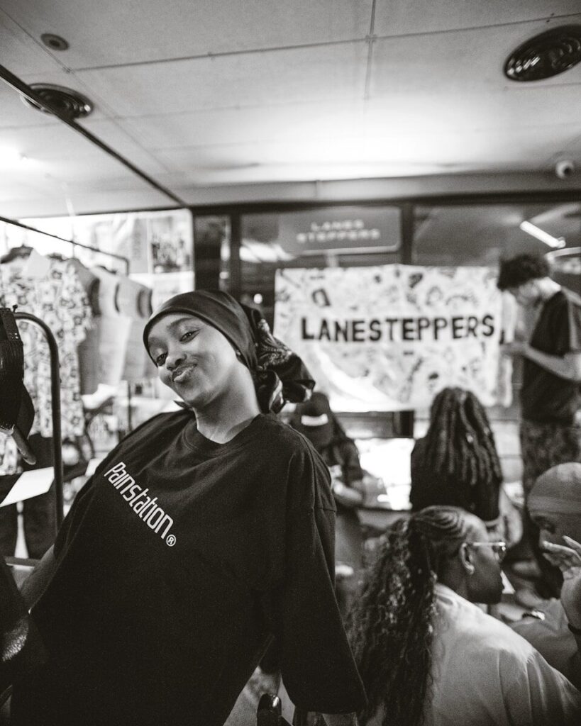 Young woman in a bandana and t-shirt smiles.