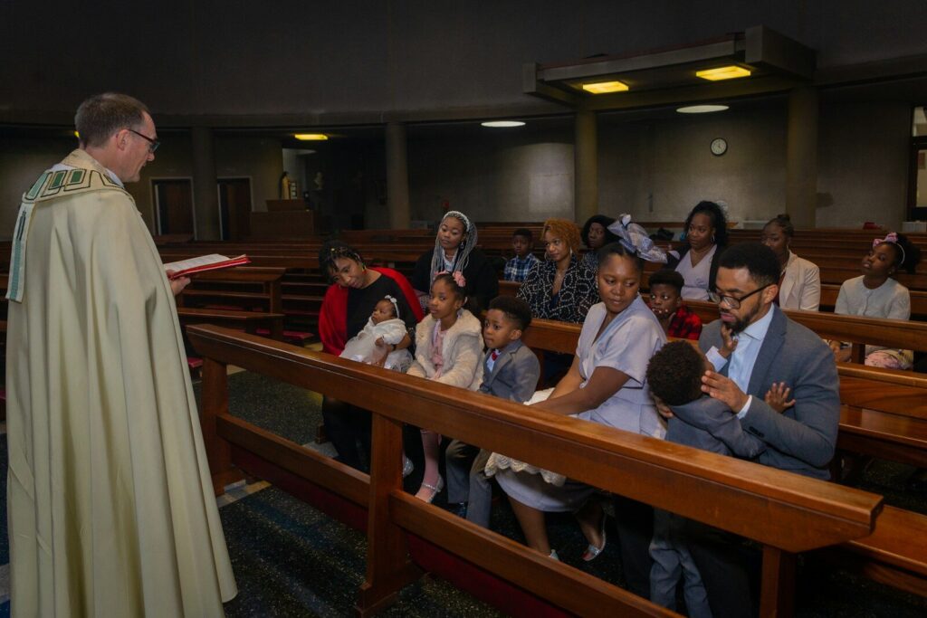 a priest standing in front of a group of people