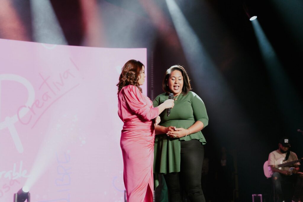 a woman standing next to a woman on a stage